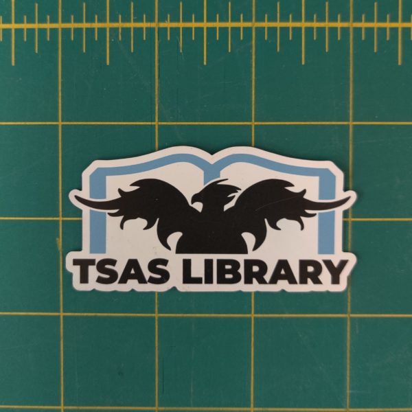 White, three inch wide magnet featuring the TSAS Library logo in black and blue